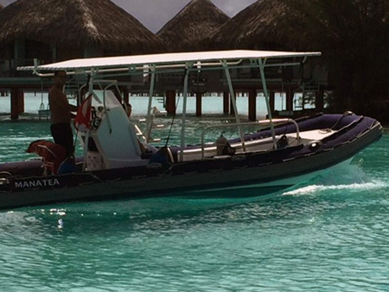 Le bateau de plongée au ponton, devant les bungalows sur pilotis