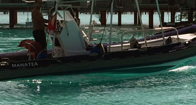 The dive boat in front of the overwater bungalows