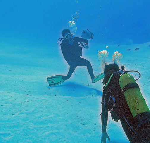 Instructor and beginner on the white sand of the lagoon
