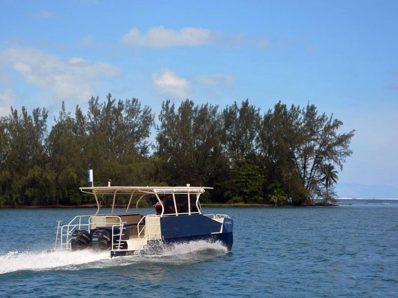 Bateau de plongée privé traversant le lagon de Bora-Bora le long d'un motu